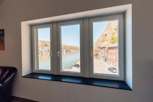 une fenêtre avec vue sur la rivière dans l'établissement Les rives de Sax, à Dinant
