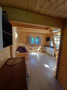 ein Zimmer mit einem Tisch und Stühlen in einer Hütte in der Unterkunft Zacisze Domek Letniskowy in Świnoujście