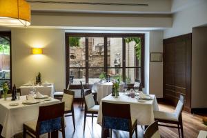 a restaurant with white tables and chairs and a window at Parador de Granada in Granada