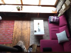 a living room with a purple couch and a table at CABAÑA VENTO NORTE in Vilamós