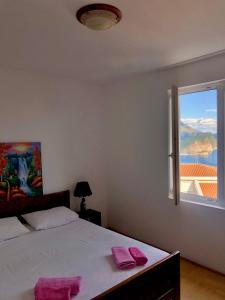 a bedroom with a bed and a large window at Apartments Violeta in Budva