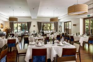 a restaurant with white tables and chairs and windows at Parador de Granada in Granada