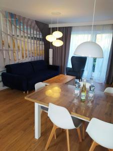 Una sala de estar con una mesa de madera y sillas blancas. en M&K Apartamenty-Amber, en Gdansk 30 fotos más