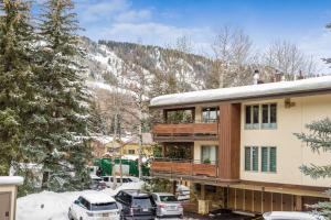 a house in the snow with cars parked in a parking lot at Little Nell Condo #3 in Aspen
