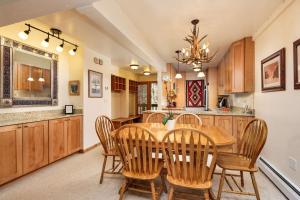 a kitchen and dining room with a wooden table and chairs at Interlude 103 in Snowmass Village