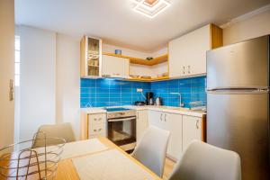 a kitchen with a table and chairs and a refrigerator at San Marco Luxury Apartment Zante in Zakynthos Town