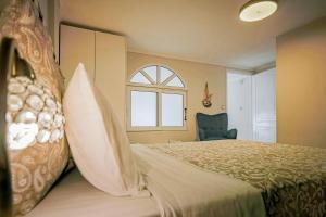 - une chambre avec un lit, une fenêtre et une chaise dans l'établissement San Marco Luxury Apartment Zante, à Zante