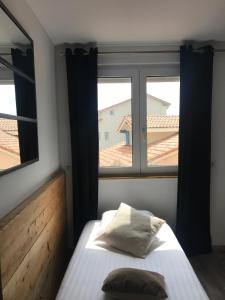 
a bedroom with a bed and a window at Hôtel Oskar in Hossegor
