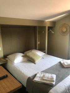 
a hotel room with a bed and a desk at Hôtel Oskar in Hossegor
