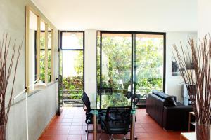 ein Wohnzimmer mit einem Glastisch und Stühlen in der Unterkunft Bean House in Vila Nova de Cerveira