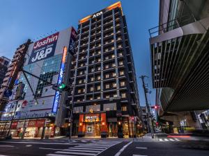 a tall building on a city street at night at APA Hotel Nambaminami Ebisucho Eki Shinsekai in Osaka