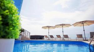 a swimming pool with chairs and umbrellas at Villa Hills in Makarska