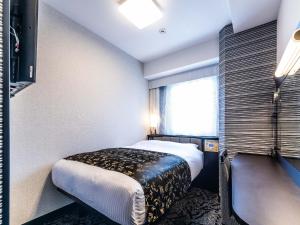a hotel room with a bed and a window at APA Hotel Nambaminami Ebisucho Eki Shinsekai in Osaka