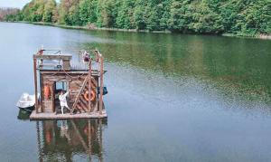 um pequeno barco no meio de um lago em Pływający Domek em Przywidz