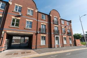 a large red brick building with a garage at City Centre Posh Parlour Gated Parking 1bed Wifi in Hull