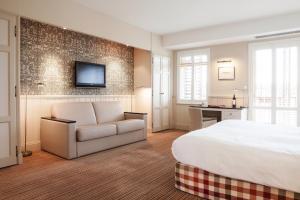 MonestierにあるRelais des Vigiersのベッドとソファ付きのホテルルーム