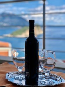 a bottle of wine sitting on a table with two glasses at Apartments Violeta in Budva