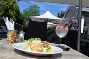 un plato de comida y una copa de vino en una mesa en Glynhill Hotel & Spa near Glasgow Airport en Renfrew