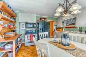 eine Küche mit einem Tisch und Stühlen sowie einem Kühlschrank in der Unterkunft Sea Spray Chalet in Coos Bay