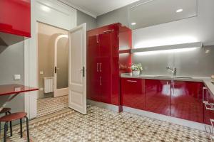 a kitchen with red cabinets and a sink at Bcn Paseo De Gracia Rocamora Apartment in Barcelona +37 photos