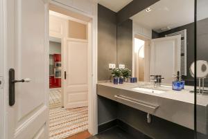 a bathroom with a sink and a mirror at Bcn Paseo De Gracia Rocamora Apartment in Barcelona