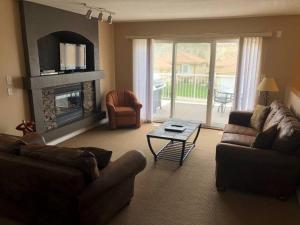 sala de estar con sofá y chimenea en Paradise Canyon Golf Resort - Luxury Condo U399 en Lethbridge