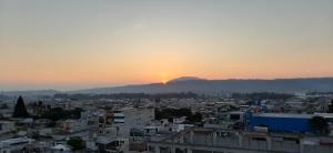 um pôr-do-sol sobre uma cidade com uma montanha ao fundo em Crysol Center Hotel em Chimaltenango