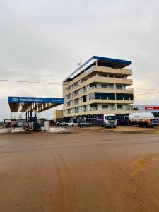 Un gran edificio con coches aparcados delante. en Hotel Universitário Goiatuba, en Goiatuba