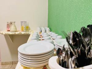 una fila de platos y cuencos sobre una mesa en Hotel Universitário Goiatuba, en Goiatuba