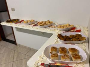 Una mesa con platos de pasteles y cuencos de comida. en Hotel Universitário Goiatuba, en Goiatuba 2 fotos más