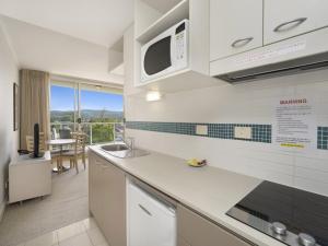 cocina con fregadero y microondas en Hinterland Luxury - 1 Bedroom Hinterland View Apt, en Ettalong Beach