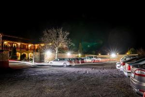 a group of cars parked in a parking lot at night at Magita Hotel in Erdőbénye