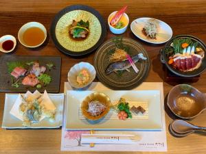 a wooden table with plates of food on it at Ikeda Onsen Ryokan Tachikawa in Ogaki