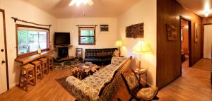 a living room with a couch and a table at Mountain Laurel Cottage at Hearthstone Cabins and Camping - Pet Friendly in Helen