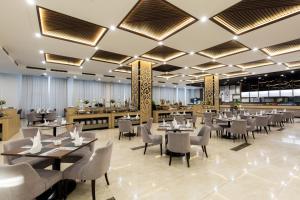 un ristorante con tavoli e sedie in una stanza di Muong Thanh Luxury Vien Trieu Nha Trang a Nha Trang