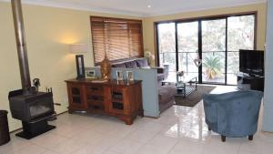 a living room with a couch and a tv at Waterfront Jervis Bay Escape Cooinda in Sanctuary Point
