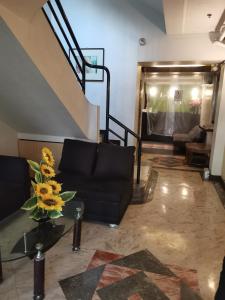 ein Wohnzimmer mit einem schwarzen Sofa und einer Treppe in der Unterkunft Jupiter Suites in Manila
