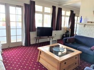 a living room with a blue couch and a coffee table at Ranfurly Hotel in Ranfurly