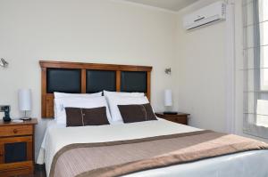 a bedroom with a large bed with a wooden headboard at Norus Las Condes in Santiago