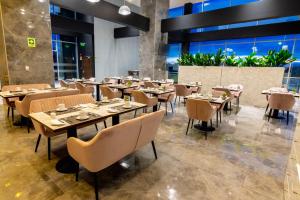 a restaurant with tables and chairs and plants at MDS Hotel Chillan in Chillán