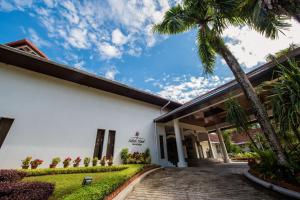 ein Gebäude mit einer Palme davor in der Unterkunft Sabah Hotel in Sandakan