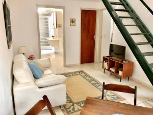 uma sala de estar com um sofá branco e uma televisão em Casa com ótima localização em Piracicaba