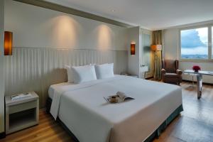 a bedroom with a large white bed and a desk at Windsor Plaza Hotel in Ho Chi Minh City