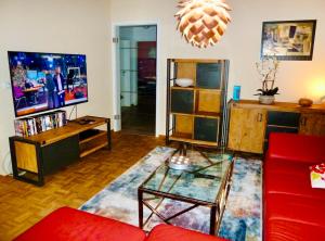 a living room with a red couch and a tv at Exklusives Wohnen am Stadtpark in Bad Driburg