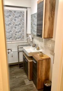 ein Bad mit einem weißen Waschbecken und einem Fenster in der Unterkunft Exklusives Wohnen am Stadtpark in Bad Driburg