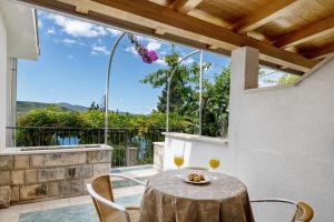 a table with two glasses of wine on a balcony at Apartments Tamaris in Neum