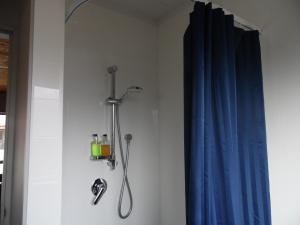 a shower in a bathroom with a blue curtain at Pinewood Motels in Fairlie