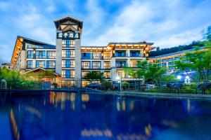 a building with a clock tower next to a body of water at SSAW Boutique Hotel Hangzhou Qiandao Lake in Chun'an