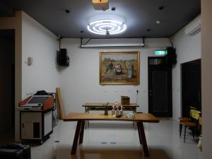 una habitación con una mesa y una foto en la pared en Happy Wing Guesthouse, en Hualien City