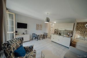kuchnia i salon z kanapą i stołem w obiekcie Apartamenty Silence Górskie Zacisze w Szklarskiej Porębie